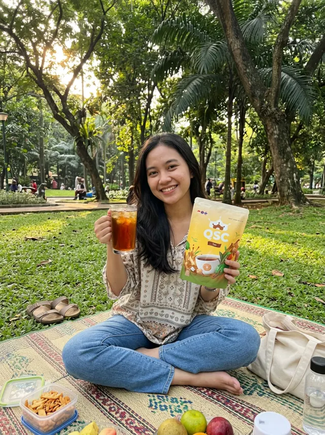 Ilustrasi piknik di taman dengan es QSC Tea